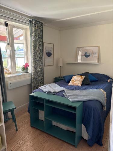 a bedroom with a blue bed and a window at Charming, quiet apartment in Kvissleby