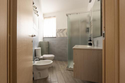 a bathroom with a toilet and a sink and a shower at La Dimora Aragonese in Randazzo