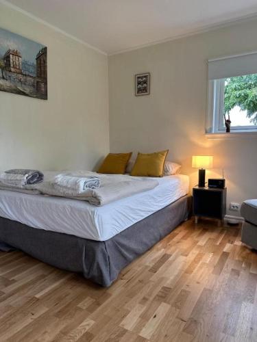 a bedroom with a large bed with a wooden floor at Small Seaside Cottage in Saltsjöbaden