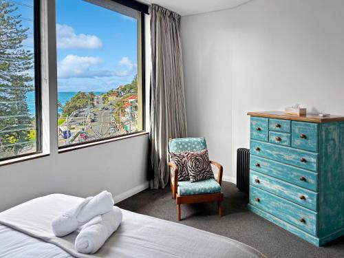 a bedroom with a window and a chair and a dresser at BRON455B - Bronte Beach House with Ocean Views in Sydney