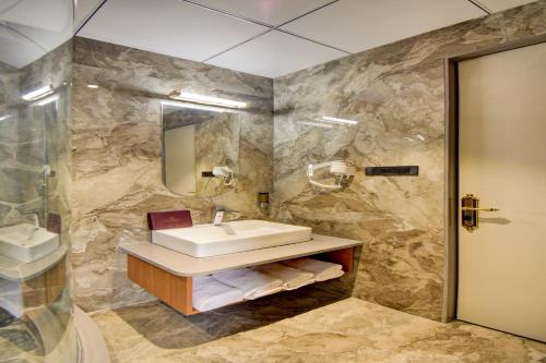 a bathroom with a sink and a mirror at Hotel Bhagyalaxmi in Shirdi