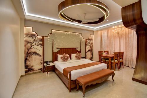 a bedroom with a large bed and a dining room at Hotel Bhagyalaxmi in Shirdi