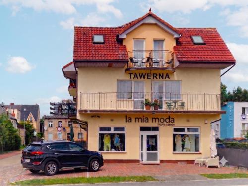 a car parked in front of a building at Tawerna Michałowscy in Mielno