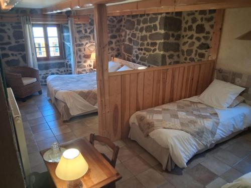 a bedroom with two beds and a table in a room at La Maison de Julia in Blanzac