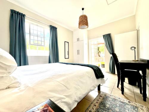 a bedroom with a bed and a desk and a piano at Cottage on 10th in Gqeberha