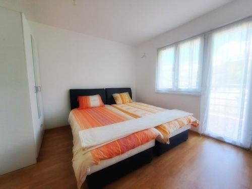 a bedroom with a bed in a room with windows at Family Nature Escape in Malešići