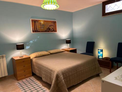 a bedroom with a bed and two blue chairs at Villa Shiva Cerveteri, Casa Vacanze con SPA e Idromassaggio, Relax a due passi da Roma in Cerveteri