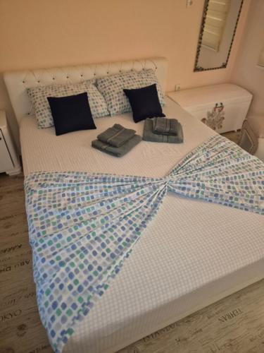 a bed with a blue and white comforter on it at Kuca za odmor Toma in Ljubuški