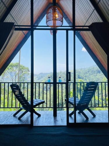 two chairs on a balcony with a view of the mountains at Nine Mist Heaven in Ella