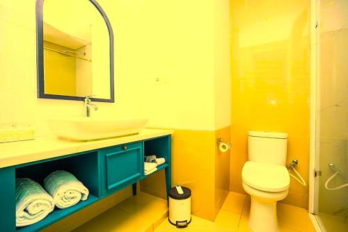 a bathroom with a sink and a toilet and a mirror at Hotel Radhakunj Inn in Dhanbād