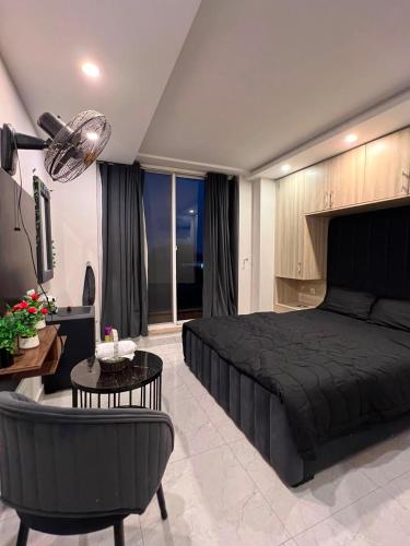 a bedroom with a black bed and a living room at Sky residences in Lahore