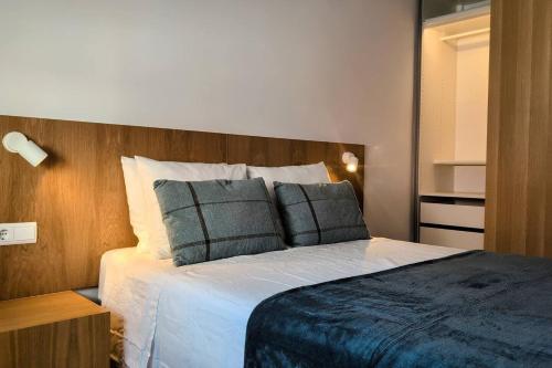 a bedroom with a large bed with two pillows at Lisbon, beach, city & surf in Trafaria
