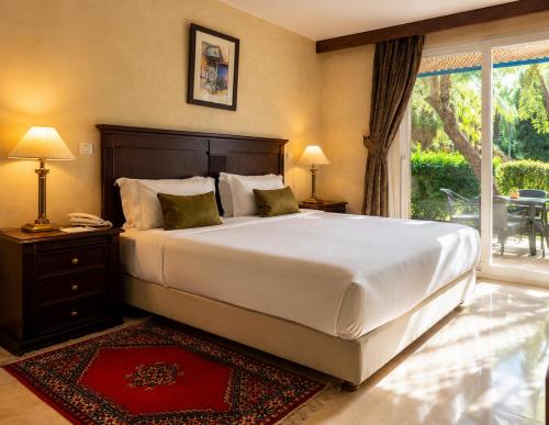 a bedroom with a large white bed and a window at Kennedy Hospitality Resort in Marrakesh