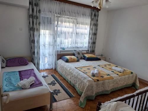 a bedroom with two beds and a window at Jasmir in Bihać
