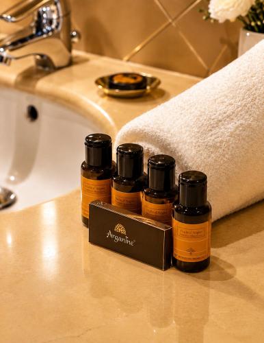 four bottles of essential oils sitting on a bathroom counter at Kennedy Hospitality Resort in Marrakesh