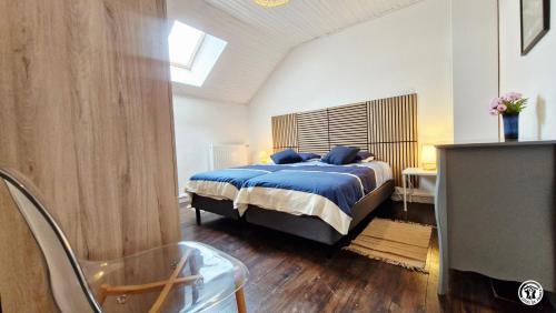 a bedroom with a bed with a blue comforter at Gîte de L'Abbaye in Nolay