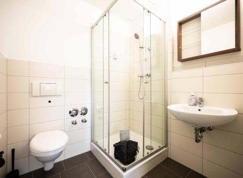 a bathroom with a shower and a toilet and a sink at N4 - Apartments Fulda Free Parking & Zentral in Fulda