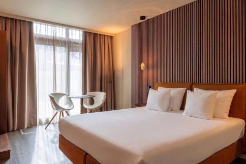 a bedroom with a large bed and a large window at Hotel Mitland in Utrecht