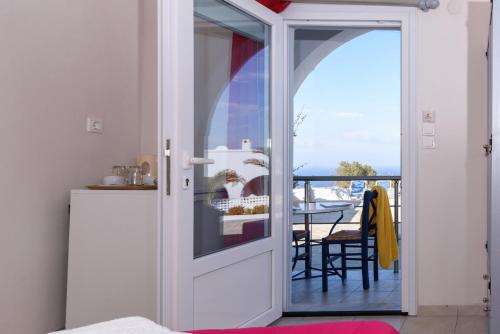 a door leading to a balcony with a table at Unique Galini Oia - Adults Only in Oia