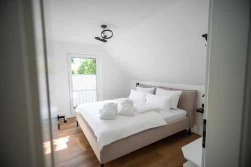 a bedroom with a white bed with two towels on it at Eickhagen Nº7 - 10 Personen - 5 Schlafzimmer - 220qm - 4 Badezimmer - Wellness - Sauna in Olsberg