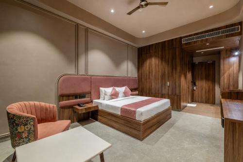 a bedroom with a bed and a chair at Hotel Highway King Dhodsar in Gūdha