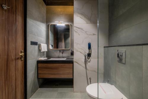 a bathroom with a toilet and a sink and a mirror at Hotel Highway King Dhodsar in Gūdha
