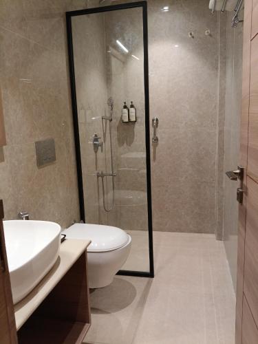 a bathroom with a shower and a toilet and a sink at MahantaINN in Faizābād