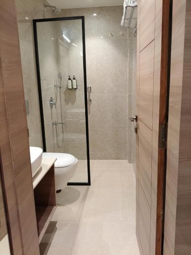 a bathroom with a shower and a toilet and a sink at MahantaINN in Faizābād