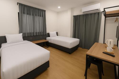 a hotel room with two beds and a desk at Houi Hotel in Jodoh