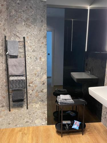a bathroom with a sink and a stool next to a mirror at Ferienwohnung Zwischenhoch in Kranenburg