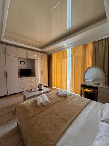 a bedroom with a large bed with towels on it at Hotel BellMar in Kobuleti