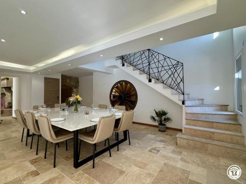 a dining room with a table and chairs and a staircase at Gîte Côté Brevon - 12 pers in Échalot
