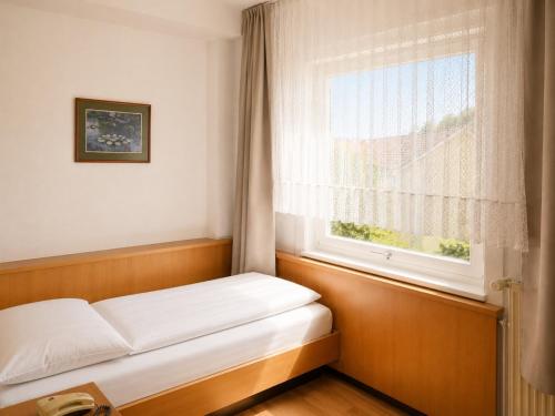 a bed in a room with a window at Hotel Kull von Schmidsfelden in Bad Herrenalb