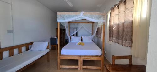 a bedroom with a bed and a canopy bed at Villa Mina beachhouse in Jambiani