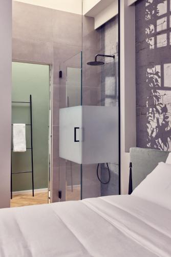 a bedroom with a white bed and a glass wall at La Dimora Guest House in Castel di Sangro