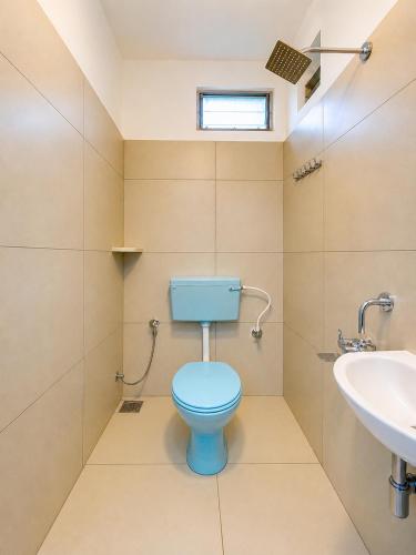 a bathroom with a blue toilet and a sink at GOOD KARMA INN Apartment in Cochin