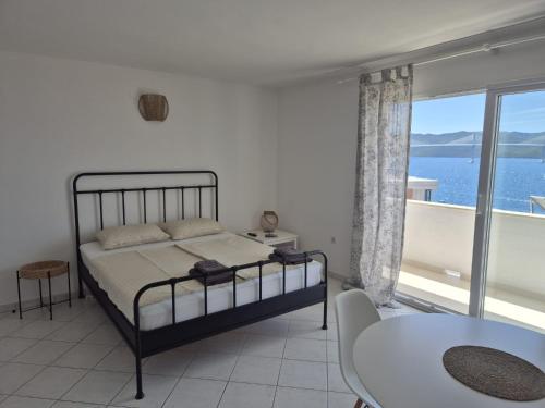 a bedroom with a bed and a view of the ocean at Apartmani More Komarna in Komarna