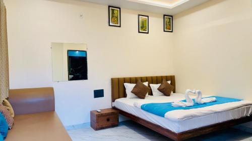 a bedroom with a bed with towel animals on it at Hotel Gurukripa Palace in Maheshwar