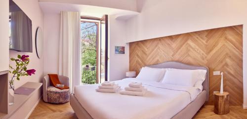 a bedroom with a white bed with towels on it at La Dimora Guest House in Castel di Sangro
