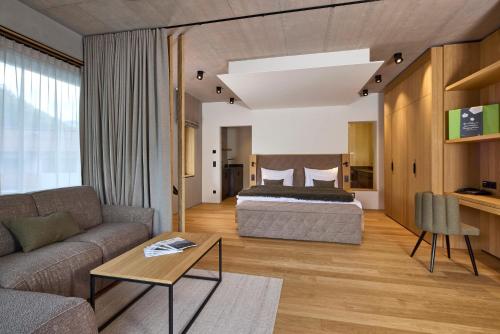 a living room with a bed and a couch at Das Lakeside - Move&Relax in Walchsee