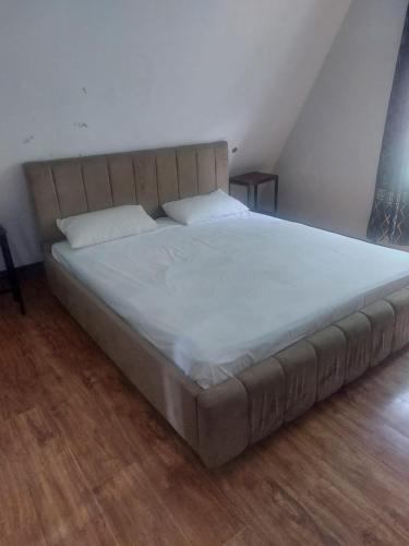 a large bed with white sheets and pillows at White Ice Cottages in Mānsehra