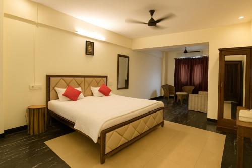a bedroom with a large bed with red pillows at Hotel The Star in Kālundri