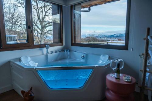a bathroom with a large tub with two windows at Casas del Tremedal in Tremedal