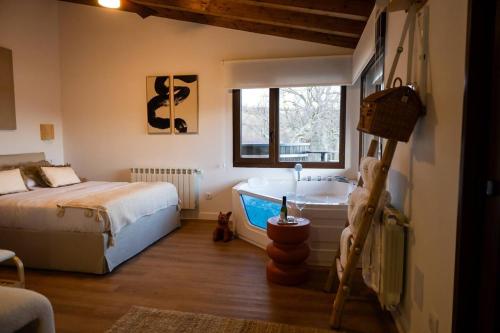 a bedroom with a bed and a bath tub at Casas del Tremedal in Tremedal