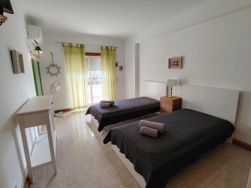 a bedroom with two beds and a desk and a room at T2 Galé Mar Retreat - Beach in Galé