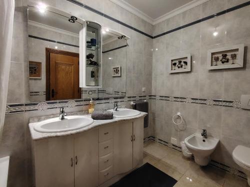 a bathroom with two sinks and a toilet and a mirror at T2 Galé Mar Retreat - Beach in Galé