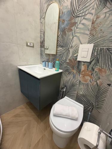 a bathroom with a sink and a toilet and a mirror at DOMUS LUIGI LEONE 2 in Naples