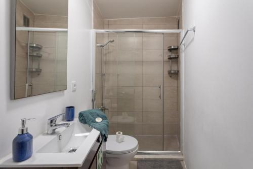 ein Badezimmer mit Dusche, Toilette und Waschbecken in der Unterkunft BeGuest Tiny Azure Apartament in Parede