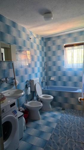 a blue tiled bathroom with a toilet and a sink at Holiday Home Nana in Bugojno