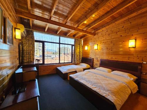 a bedroom with two beds in a wooden cabin at Hotel Kocibelli POOL & SPA in Korçë